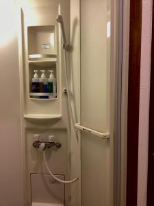 um frigorífico branco com garrafas de água em Osaka Namba Hostel MIYABI em Osaka