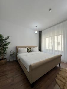 a bedroom with a large bed and a window at Cloud 9 Studios in Piatra Neamţ