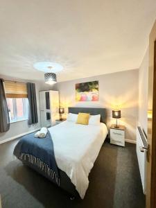 una camera con un grande letto e due lampade di Lux Home Stays - Regents Place a Leamington Spa