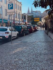 una strada con auto parcheggiate sul lato di una strada di Happy Holiday Sintra a Sintra