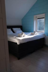 uma cama grande num quarto com uma janela em Luxury home Egmond em Egmond aan Zee