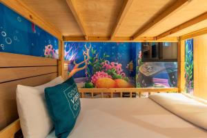曼谷的住宿－Cross Vibe Bangkok Sukhumvit，一间设有一张床铺的房间,墙上挂着一幅鱼画