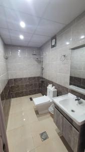 ein Badezimmer mit einer weißen Toilette und einem Waschbecken in der Unterkunft Rum Gonesh Luxury Camp in Wadi Rum + 74 Fotos