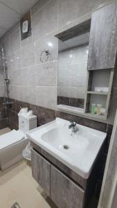 ein Badezimmer mit Waschbecken, Toilette und Spiegel in der Unterkunft Rum Gonesh Luxury Camp in Wadi Rum