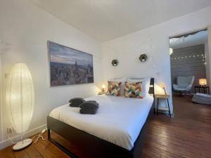 a bedroom with a large bed with white sheets at Cocon boisé x Parking by Melrose in Bayeux