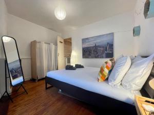a bedroom with a large bed and a mirror at Cocon boisé x Parking by Melrose in Bayeux