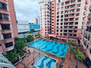 - une vue sur la piscine située dans une ville dotée de grands bâtiments dans l'établissement Marina Court Resthouse KK, à Kota Kinabalu