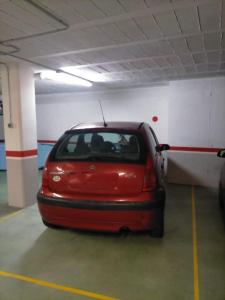 El rinconcito de Aldán في ألدان: سيارة حمراء متوقفة في مرآب للسيارات