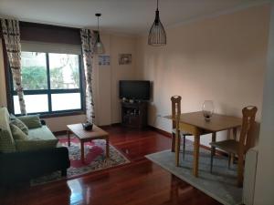 a living room with a table and a tv at El rinconcito de Aldán in Aldán