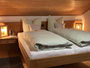 Dos camas con almohadas en un dormitorio. en Ferienhaus Kögel, en Nesselwang