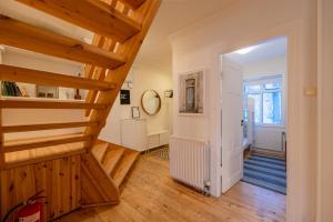 a hallway with wooden floors and a staircase in a house at Day Dream Central Akureyri Three Bedroom Apt in Akureyri