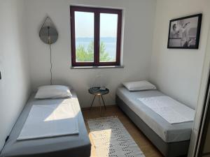 two beds in a room with a window at Sara Brela Apartment in Brela