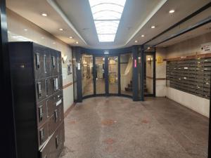 大阪MORI Apartment Dotonbori 2DK的天花板建筑中带储物柜的走廊