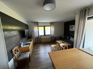 een woonkamer met een bank en een tafel bij Ferienwohnung am Hillestausee in Winterberg