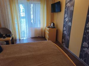 a bedroom with a bed and a television and a window at Pokoje Gościnne Wanda in Władysławowo