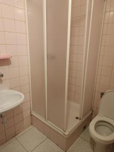 a bathroom with a shower with a toilet and a sink at Pokoje Gościnne Wanda in Władysławowo +15 photos
