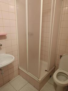 a bathroom with a shower with a toilet and a sink at Pokoje Gościnne Wanda in Władysławowo