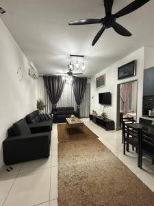 een woonkamer met een zwarte bank en een plafondventilator bij Parc Regency Tiara Homestay in Johor Bahru