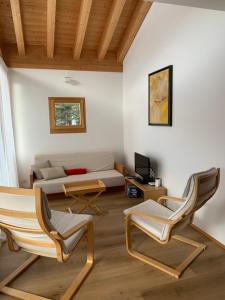 uma sala de estar com duas cadeiras e um sofá em Chesa Chavriol em Pontresina