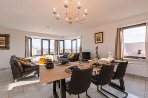 - un salon avec une table à manger et des chaises dans l'établissement Spacious & modern sea view apartment with garage, à Ostende