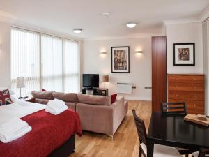 ein Schlafzimmer mit einem Bett, einem Sofa und einem Tisch in der Unterkunft Your Space Apartments - Byron House in Cambridge