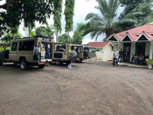 dos vehículos militares estacionados frente a una casa en Home Feeling Neneu Lodge en Moshi
