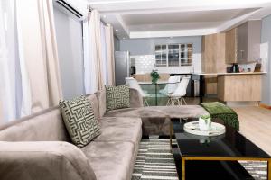 a living room with a couch and a table at Uptown Apartments - Casalinga Villas in Mataffin