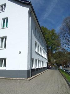 ein weißes Gebäude mit weißen Fenstern auf einer Straße in der Unterkunft Linden 4 in Monschau