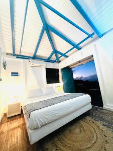 - une chambre avec un grand lit et des poutres bleues dans l'établissement Vue Mer/3Beds/Piscine/wifi/900 mètres de la plage, à Deshaies