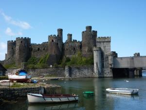 a castle with boats in the water in front of it at Cosy 1 Bedroom Apartment in the Heart of Llandudno in Llandudno