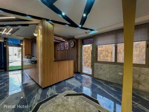 eine Eingangshalle eines Gebäudes mit einer Uhr an der Wand in der Unterkunft Pretal Hotel in Al Mafraq