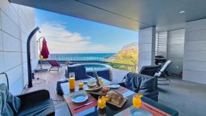 a living room with a table and a view of the ocean at Over the Cliff Apartment by LovelyStay in Funchal
