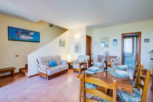 comedor y sala de estar con mesa y sillas en Falke House relax and lake view - Happy Rentals, en Puegnago sul Garda