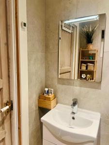 y baño con lavabo blanco y espejo. en Cozy Heaven! Just 17 min's to Central, en Hedehusene