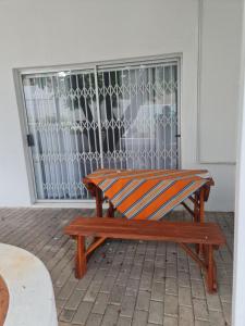 un banc en bois assis devant une porte dans l'établissement Villa Saffier, à Windhoek