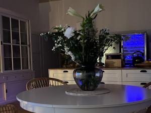 eine Vase mit Blumen auf dem Tisch in der Küche in der Unterkunft Löftchen in Roetgen