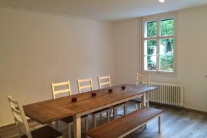 a dining room with a wooden table and chairs at Maison Riviére in Monschau