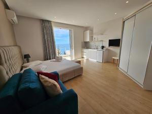 a hotel room with a bed and a couch at Dani's Apartments in Sarandë