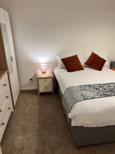 a bedroom with two beds and a lamp on a night stand at 2 bed Solihull near NEC Airport, JLR, Resort Wrld in Solihull