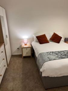una camera con 2 letti e una lampada su un comodino di 2 bed Solihull near NEC Airport, JLR, Resort Wrld a Solihull