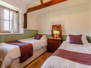 Un dormitorio con dos camas y una ventana. en 2 Bed in South Molton 86642, en Knowstone
