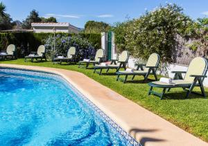 una piscina con tumbonas y sillas junto a en Casa Segaria, en Denia