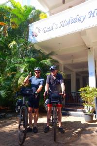 dois homens de pé com bicicletas em frente a um hotel em Dad's Holiday Home em Matale