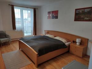 um quarto com uma cama, uma cadeira e uma janela em Hezké ubytování v centru města em Trebic