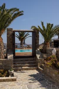 a door leading to a pool with palm trees at Maryo Village in Naousa