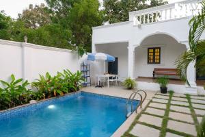 a villa with a swimming pool and a house at StayVista at Agam Villa Mahabalipuram in Chennai