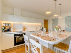 a kitchen with a white table and white chairs at 1 Bed in Hythe 89968 in Hythe
