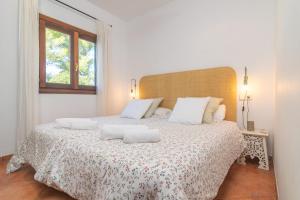 um quarto branco com uma cama grande e 2 almofadas em Ca Na Matas em Son Serra de Marina