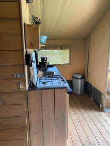 uma cozinha com um fogão e um lavatório numa tenda em Luxe safaritent aan het water em Hommerts