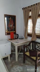 een wit bureau met een stoel en een foto aan de muur bij Full Moon Resort in Unawatuna